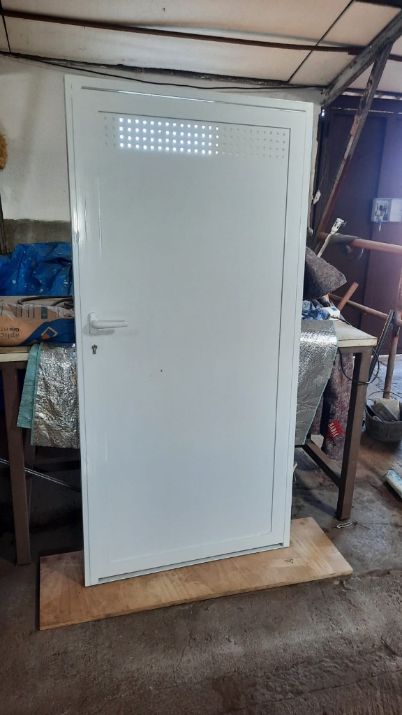 Puerta metálica blanca fabricada a medida instalada por H&L